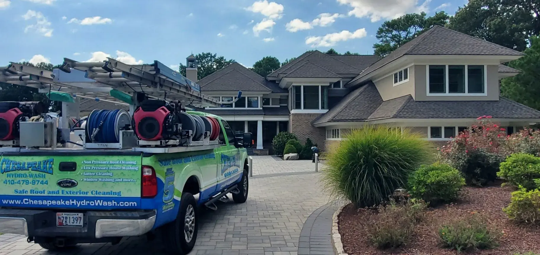 Chesapeake Hydro-Wash trucks positioned beside a roof during safe roof cleaning service